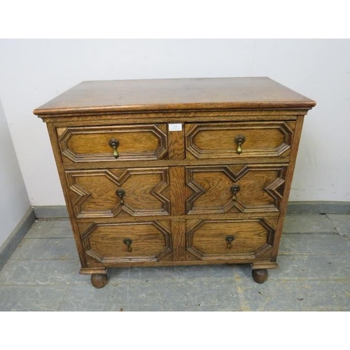 820 - An antique oak chest in the Jacobean style, housing three long graduated drawers with geometric spli... 