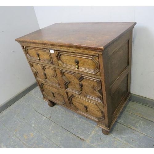 820 - An antique oak chest in the Jacobean style, housing three long graduated drawers with geometric spli... 