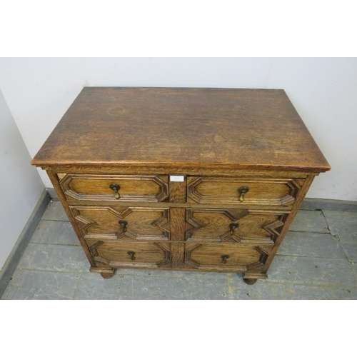 820 - An antique oak chest in the Jacobean style, housing three long graduated drawers with geometric spli... 