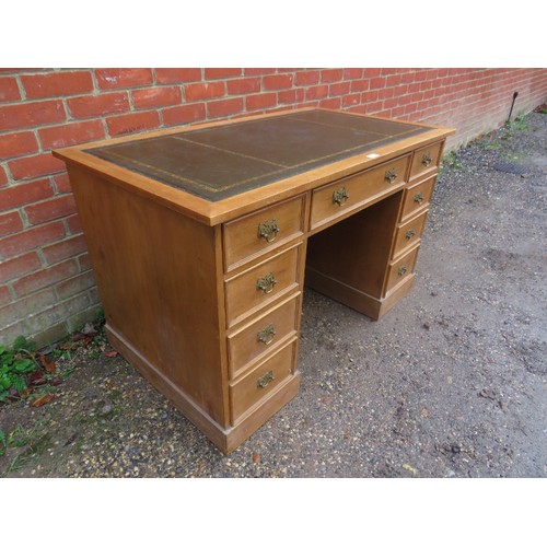 807 - An antique pine kneehole desk, the top with inset gilt tooled green leather surface, housing nine gr... 