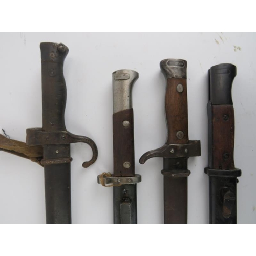 294 - Four antique bayonets with scabbards, late 19th/early 20th century. Possibly German. (4 items) 52.9 ... 