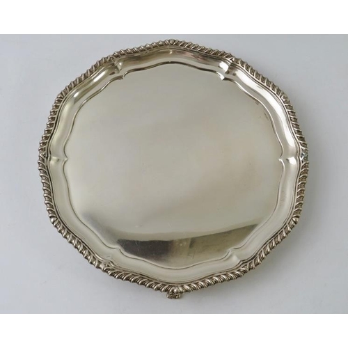 360 - A Georgian style silver salver with gadrooned edge and standing on three feet. Hallmarked for Sheffi... 