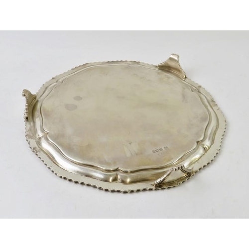 360 - A Georgian style silver salver with gadrooned edge and standing on three feet. Hallmarked for Sheffi... 