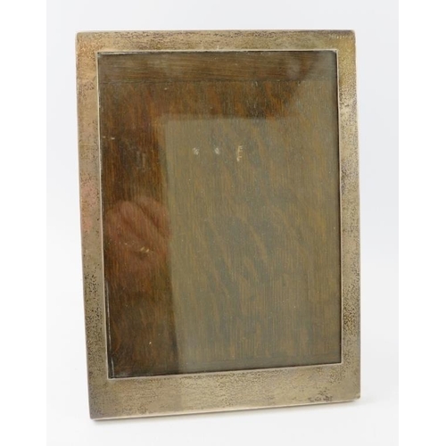 392 - An early 20th century glazed silver picture frame on oak easel back. Hallmarked for Chester 1919, ma... 