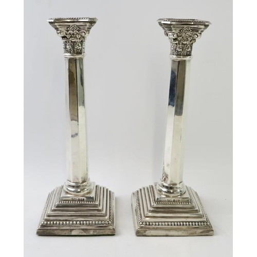 397 - A pair of silver Corinthian column candlesticks on square bases and with octagonal columns. Hallmark... 