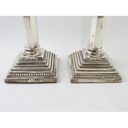 397 - A pair of silver Corinthian column candlesticks on square bases and with octagonal columns. Hallmark... 