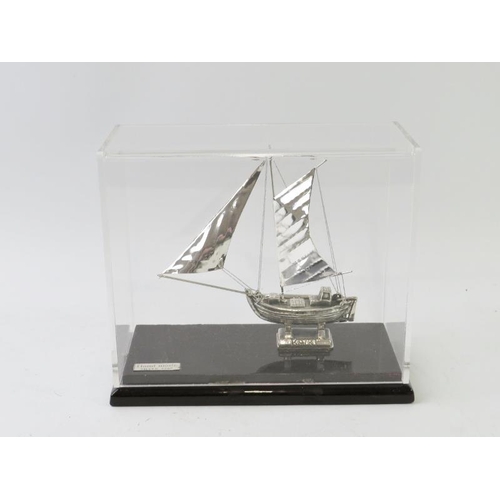 405 - A white metal model sail boat inscribed KAIKI and housed in a clear perspex case. Plaque stamped 'Ha... 