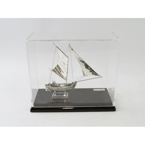 405 - A white metal model sail boat inscribed KAIKI and housed in a clear perspex case. Plaque stamped 'Ha... 