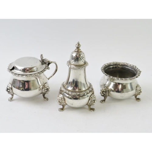 406 - A good quality Harrods silver three piece Georgian style cruet set with gadrooned rims, lion mask le... 