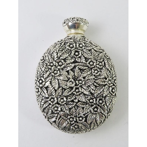 410 - An ornate Continental white metal perfume bottle with floral and foliate decoration and inset cameo ... 