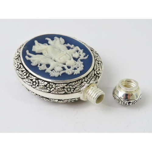 410 - An ornate Continental white metal perfume bottle with floral and foliate decoration and inset cameo ... 