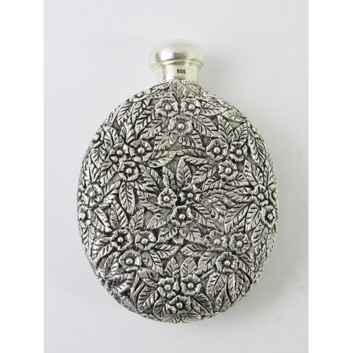 412 - An ornate Continental white metal perfume bottle with floral and foliate decoration and inset cameo ... 