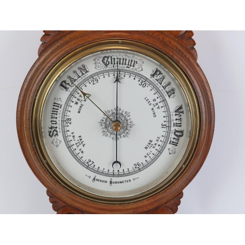 45 - An antique oak cased aneroid barometer and thermometer, late 19th/early 20th century. Of banjo form.... 