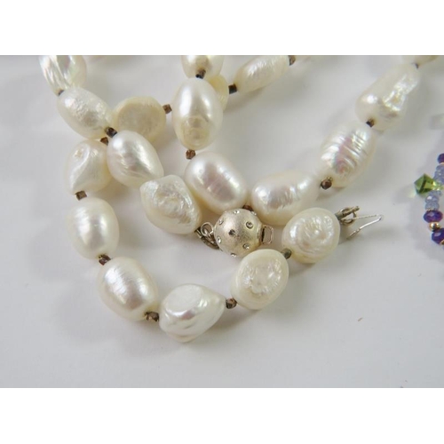 455 - A baroque fresh water pearl and metallic bead long rope necklace, with decorative yellow metal ball ... 