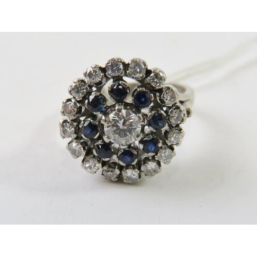 471 - A diamond and synthetic blue spinel cluster ring of target design, the central round brilliant cut d... 