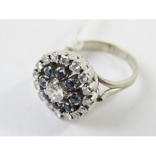 471 - A diamond and synthetic blue spinel cluster ring of target design, the central round brilliant cut d... 