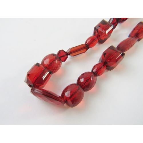 474 - A faceted ‘cherry amber’ necklace and pair of matching drop earrings.  
Condition report: 122gms gro... 