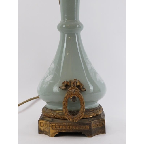 48 - A French ormolu mounted pâte-sur-pâte decorated celadon glazed porcelain table lamp, 19th century. O... 