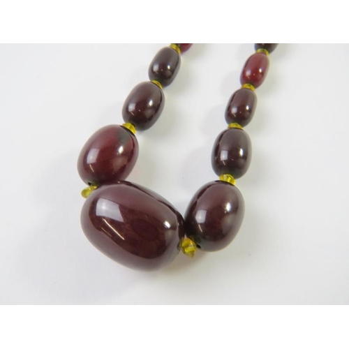 490 - A graduated strand of red amber beads, ranging from 11mm to 33mm lengths, 54gms approx