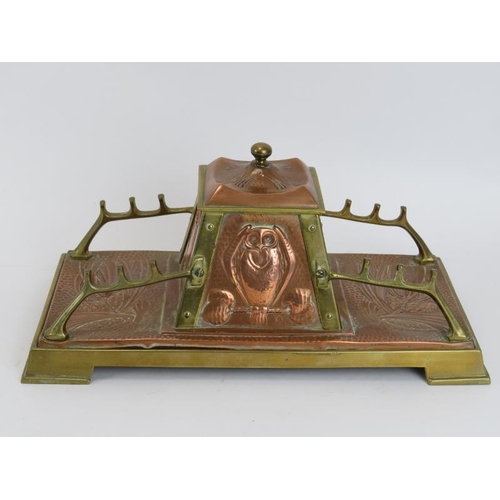 84 - An Arts & Crafts copper and brass desktop inkwell, late 19th/early 20th century. The central inkwell... 