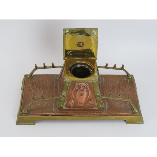 84 - An Arts & Crafts copper and brass desktop inkwell, late 19th/early 20th century. The central inkwell... 