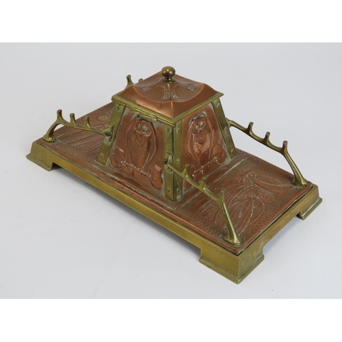 84 - An Arts & Crafts copper and brass desktop inkwell, late 19th/early 20th century. The central inkwell... 