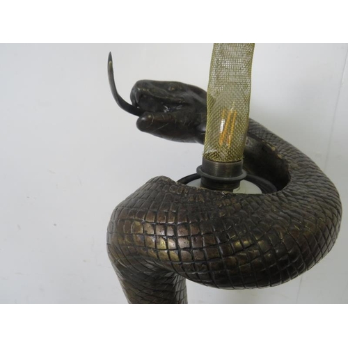 711 - A bronze floor lamp after Edgar Brandt, modelled as a coiled snake. 
H153 x Diameter 31cms (approx)
... 