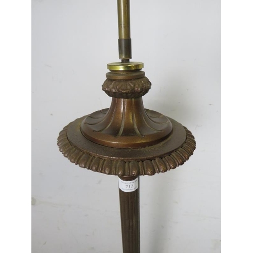 712 - A cast iron bronzed floor lamp in the classical taste, the tapered fluted column on three lion’s paw... 