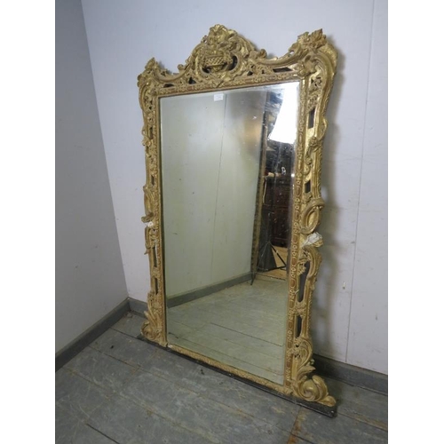 714 - A large 19th century bevelled overmantle mirror, within an orate gilt gesso frame modelled as fruit ... 