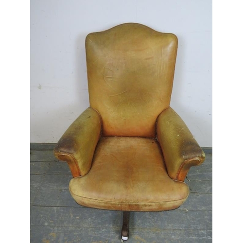 718 - A vintage high-backed revolving desk chair, upholstered in distressed tan leather with brass studs, ... 