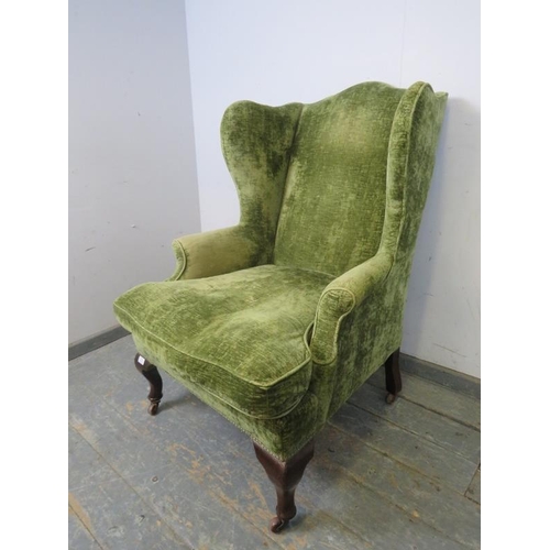 768 - A 19th century wingback armchair, recovered in jade green distressed velvet, on mahogany ogee suppor... 