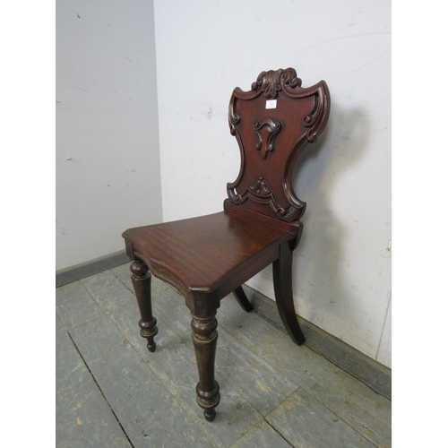 769 - A Victorian mahogany hall chair, having a carved and pierced backrest, on turned tapering front supp... 