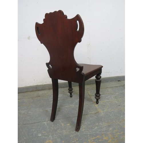 769 - A Victorian mahogany hall chair, having a carved and pierced backrest, on turned tapering front supp... 