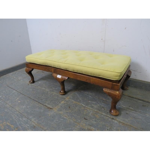 770 - A 1920s walnut long footstool, the bergere top with loose squab cushion recovered in buttoned pale-y... 