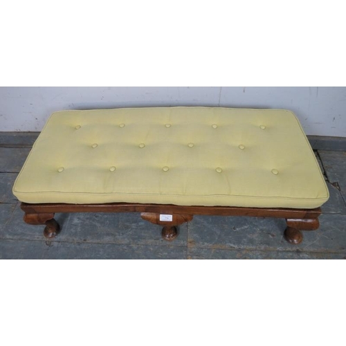 770 - A 1920s walnut long footstool, the bergere top with loose squab cushion recovered in buttoned pale-y... 