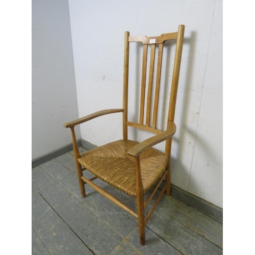 772 - An Arts & Crafts beech rush-seated elbow chair, on turned supports with stretchers. 
H102cm W54cm D4... 