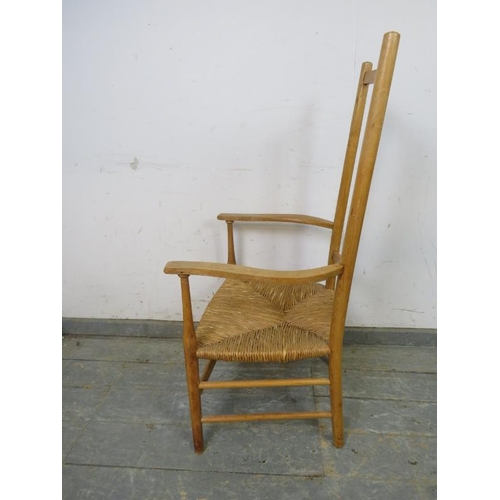 772 - An Arts & Crafts beech rush-seated elbow chair, on turned supports with stretchers. 
H102cm W54cm D4... 