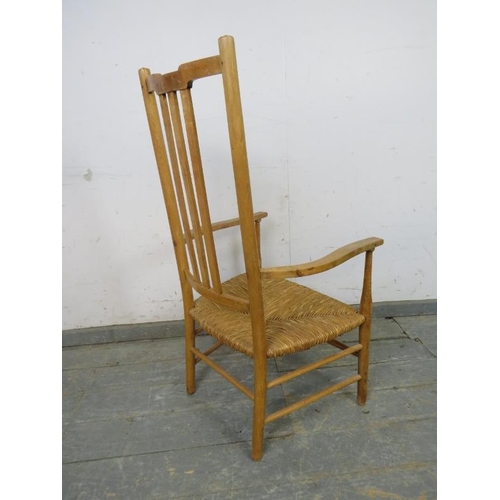 772 - An Arts & Crafts beech rush-seated elbow chair, on turned supports with stretchers. 
H102cm W54cm D4... 