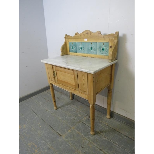 775 - An antique pine washstand, the rear gallery with inset Art Nouveau mint green tiles, above a white m... 