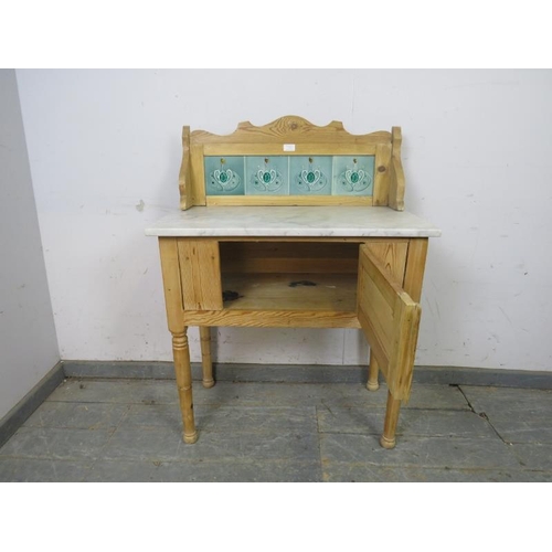 775 - An antique pine washstand, the rear gallery with inset Art Nouveau mint green tiles, above a white m... 