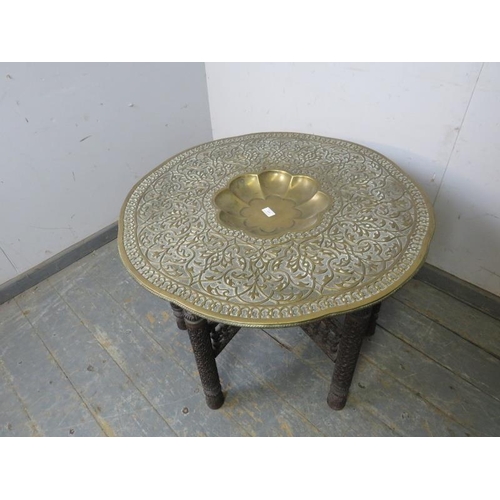 800 - An antique Benares table, the brass tray top with profuse foliate decoration and central well, on a ... 