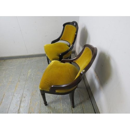 807 - A matched pair of ebonised salon chairs, upholstered in mustard velour with brass studs, on tapered ... 