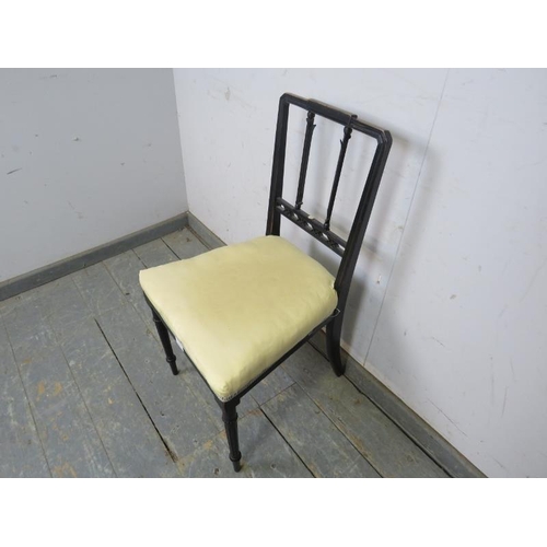 810 - An Aesthetic Movement ebonised boudoir chair, reupholstered in pale yellow satin, on tapering reeded... 