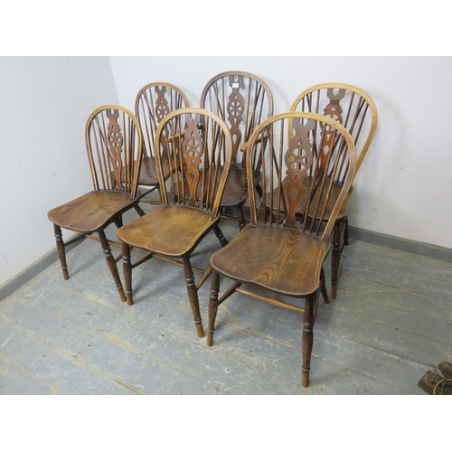 814 - A set of six (5+1) antique elm and beech wheelback chairs, on turned supports with an ‘H’ stretcher.... 