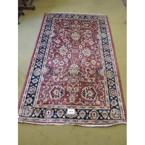 860 - A 20th Century wool rug. Central floral pattern on a dusky pink ground. 253cm x 160cm approx.
Condit... 