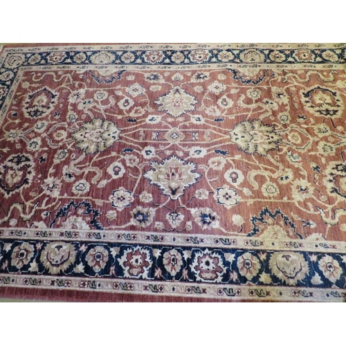 860 - A 20th Century wool rug. Central floral pattern on a dusky pink ground. 253cm x 160cm approx.
Condit... 