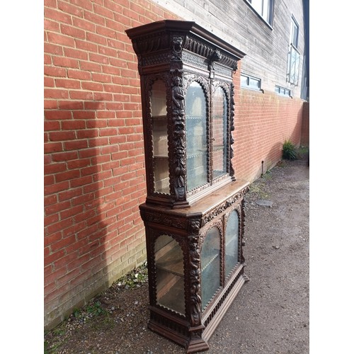 720 - A 19th century oak glazed display cabinet, profusely carved in the 17th century taste with caryatids... 