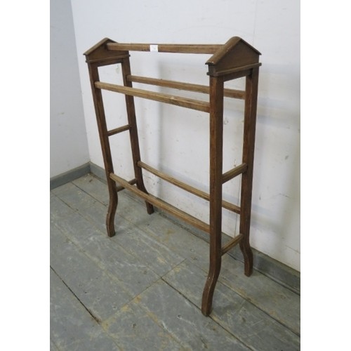 748 - An antique beech double towel rail, with architectural pediments to either end, on splayed supports.... 