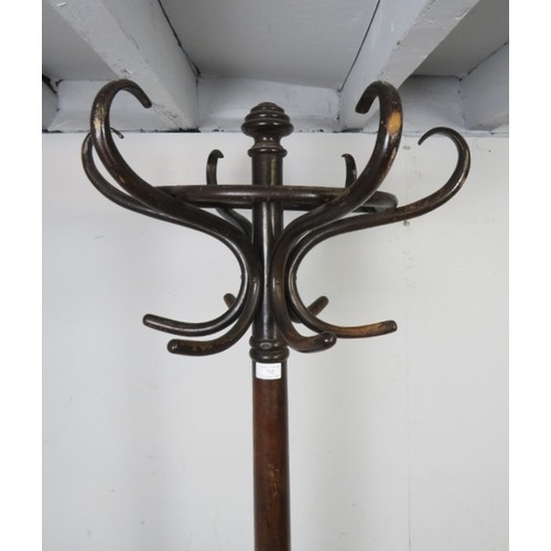 752 - An antique bentwood hat stand, having six double hooks above divided stick stand compartments, on sp... 