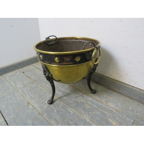 740A - An Arts & Crafts Period circular brass log bin, with repousse roundel decoration and ring handles to... 